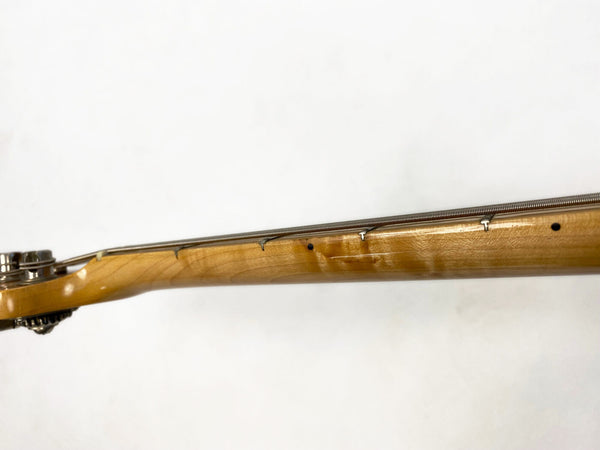 Close-up view of maple guitar neck with metal frets and black dot inlays against white background