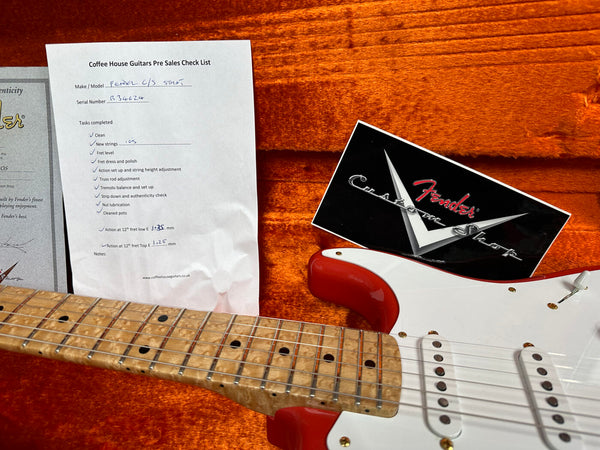 Close-up of Fender Custom Shop Stratocaster guitar neck and body with Coffee House Guitars pre sales checklist and Fender Custom Shop certificate in orange plush guitar case interior