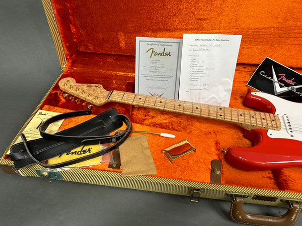 Fender Stratocaster guitar with red body and figured maple neck in orange plush-lined tweed hard case, including certificate of authenticity, pre-sales checklist, leather strap, tremolo arm, and Fender polishing cloth