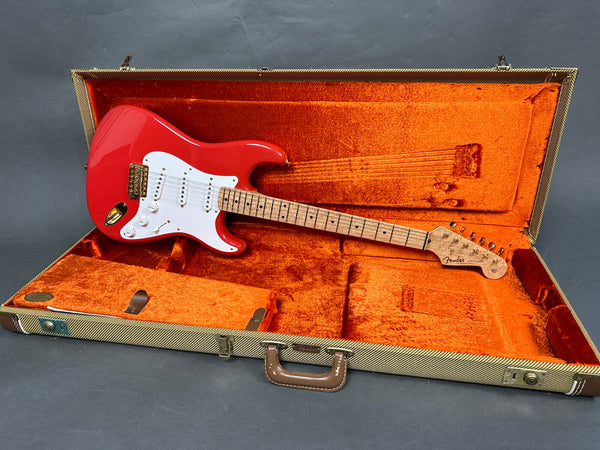 Red Fender Stratocaster electric guitar with white pickguard and maple neck in open vintage tweed hard case with orange plush interior
