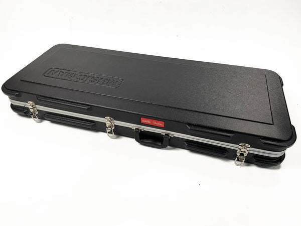 Black Music Man hard guitar case with metal latches and handle, labeled StingRay, for electric bass guitar storage and transport.