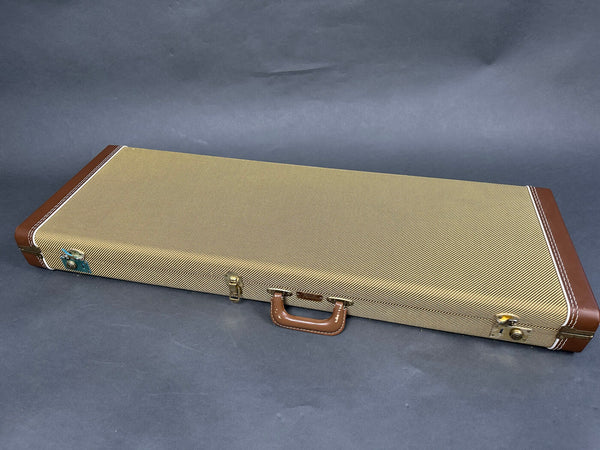 Vintage style rectangular guitar case with brown leather corners and handle, beige textured exterior, and metal latches on gray background