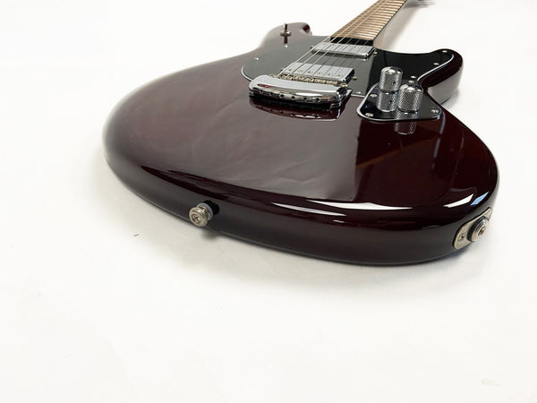 Close-up of dark brown electric guitar body with chrome bridge and control knobs on white background