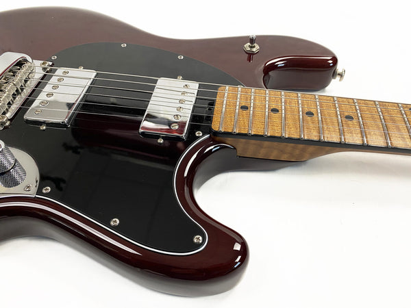 Close-up of dark red electric guitar body with black pickguard, chrome humbucker pickups, and natural wood maple fretboard with dot inlays on white background