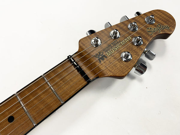Ernie Ball Music Man StingRay electric guitar headstock with tuning pegs and strings on wooden neck against white background