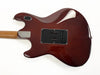 Back view of Ernie Ball Music Man electric guitar with glossy dark red finish and natural wood neck on white background