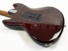 Rear view of dark red electric guitar body with black backplate and maple neck at Coffee House Guitars