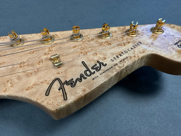 Close-up of Fender Stratocaster guitar headstock with synchronized tremolo and gold tuning pegs on birdseye maple wood finish