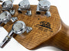 Close-up of California Heritage wood guitar headstock with chrome tuning pegs and engraved bear logo since 1974