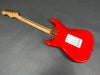 Red electric guitar back view with birdseye maple neck and gold tuning pegs on gray background