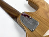 Close-up of Ernie Ball Music Man guitar neck plate with serial number 686265 on natural wood finish body and neck.