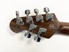 Back of acoustic guitar headstock showing chrome tuning pegs and loaded with "California Heritage Since 1974" logo and bear emblem on polished wood finish