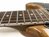 Close-up of electric guitar rosewood fretboard with metal frets and white dot inlays, natural wood body with glossy finish at Coffee House Guitars