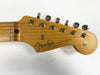 Close-up of Fender Stratocaster guitar headstock with original tuners and logo on natural wood finish against white background