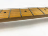Close-up of maple guitar neck with metal frets and dot inlays on the fretboard, steel guitar strings, white background