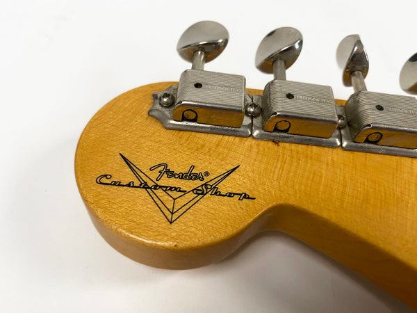 Close-up of Fender Custom Shop guitar headstock with vintage tuners and logo on natural wood finish