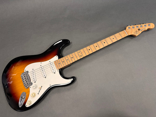 Vintage G&L Legacy electric guitar in sunburst finish with maple neck and white pickguard on gray background