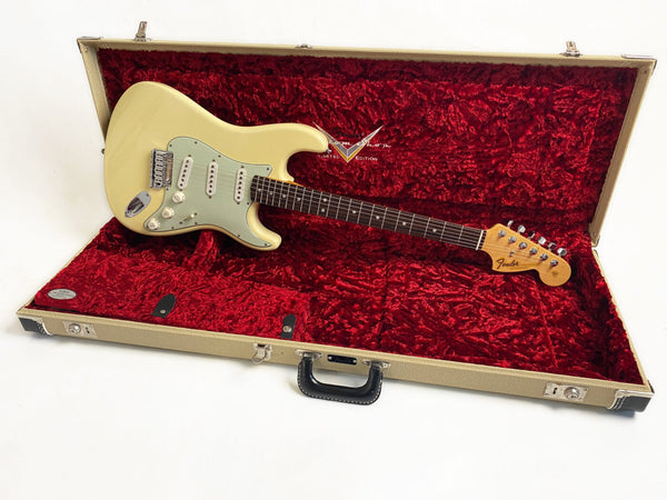 Fender Stratocaster electric guitar in vintage white with mint green pickguard resting in open plush red-lined beige hardshell guitar case