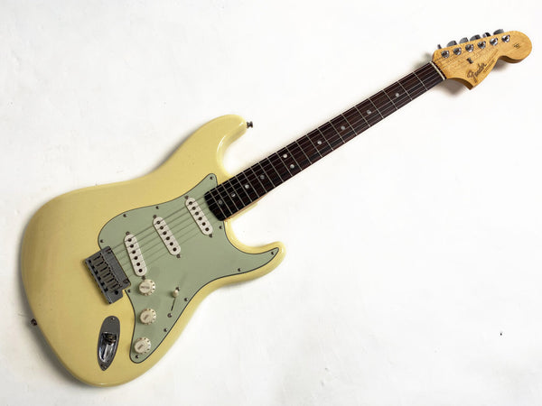 Vintage cream Fender Stratocaster electric guitar with rosewood fretboard and three single-coil pickups on white background