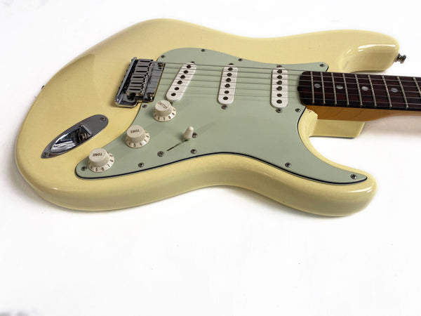 Vintage cream electric guitar with three single-coil pickups and mint green pickguard on white background