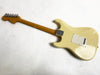 Back view of cream-colored electric guitar with maple neck and six tuning pegs on headstock, showing rear tremolo cover plate and neck plate with screws on white background