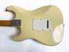 Back view of vintage cream electric guitar body with white backplate and metal neck plate screws on white background