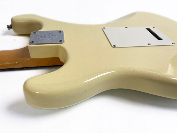 Close-up of cream-colored vintage electric guitar body showing neck joint plate and back cavity cover with visible crackling finish and wooden neck