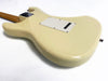 Back of cream-colored electric guitar body with visible tremolo cavity cover and neck plate on white background
