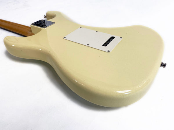Back of cream-colored electric guitar body with visible tremolo cavity cover and neck plate on white background
