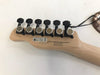 Close-up of guitar headstock back showing six black tuning pegs with silver tuning buttons, natural wood finish, and label stating "C.F.S. is installed on this instrument, Made in Japan" with compliance and patent information.