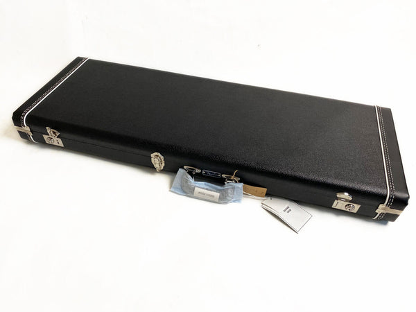 Black rectangular hard shell guitar case with silver latches and white stitching, labeled Fender, with handle wrapped in protective plastic.