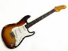 Vintage Fender Stratocaster electric guitar with sunburst finish and worn body on white background