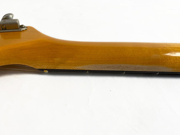 Close-up view of guitar neck and fretboard side with vintage-style tuning peg, honey-colored wood finish on white background