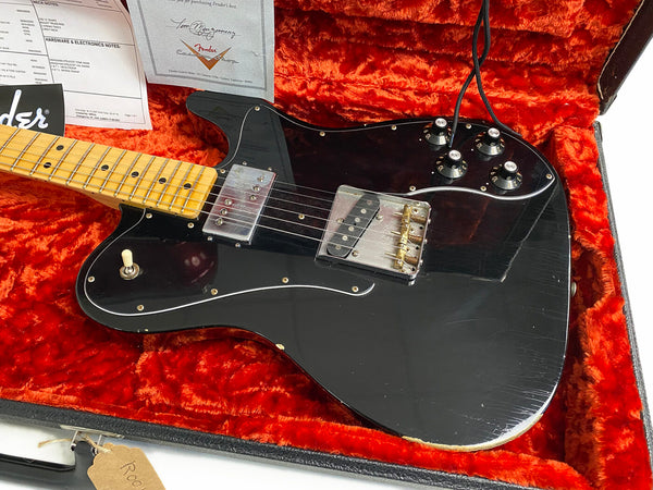 Black Fender electric guitar with maple neck and chrome hardware in red plush-lined guitar case with Fender authenticity papers