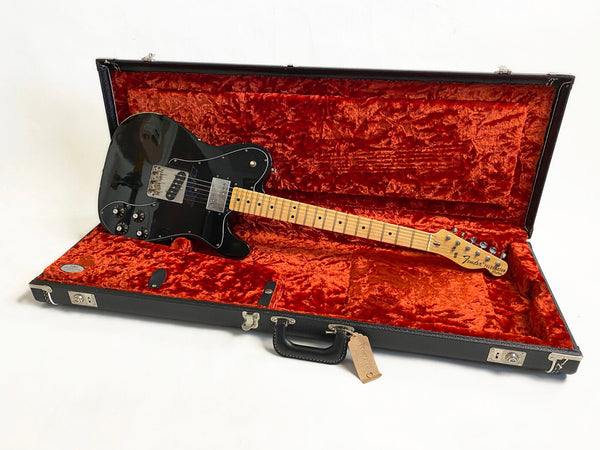 Black Fender Telecaster electric guitar with maple neck and fretboard in open black hard case with red plush interior lining