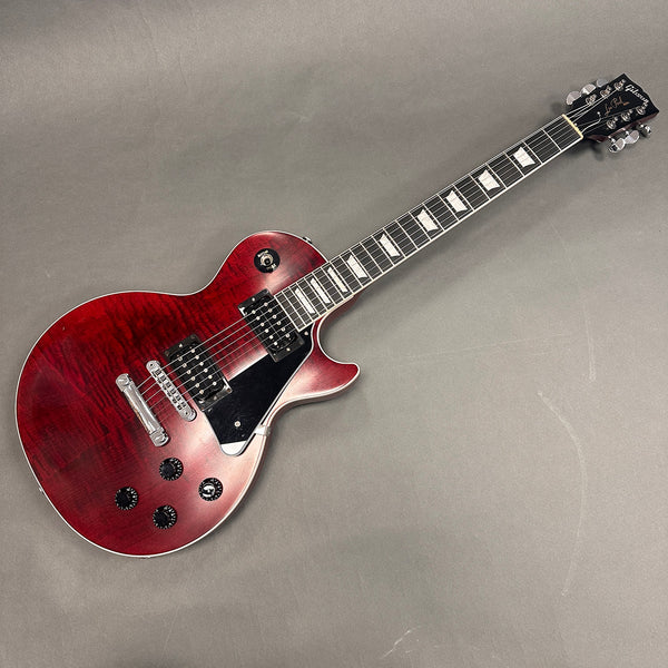 Gibson Les Paul electric guitar with cherry sunburst finish, dual humbucker pickups, black pickguard, and chrome hardware on gray background