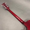 Back view of red electric guitar neck and headstock with chrome tuning pegs on gray background from Coffee House Guitars