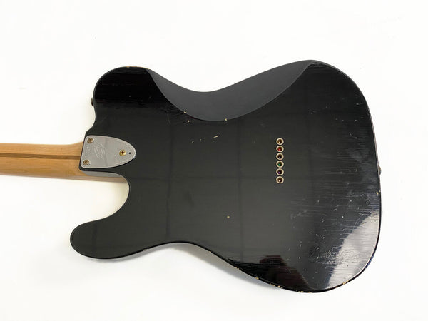 Black Fender Telecaster electric guitar back body with string ferrules and maple neck on white background