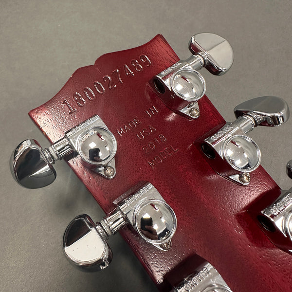 Close-up of red guitar headstock with chrome Grover tuning pegs, serial number 180027489, and "Made in USA 2018 Model" stamped on the back.
