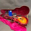Gibson Les Paul electric guitar with sunburst finish in open brown hardshell case with red plush interior and Gibson warranty cards and accessories