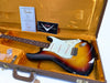 Fender Custom Shop Stratocaster electric guitar in sunburst finish inside vintage brown hardshell case with orange interior, includes Fender Custom Shop Certificate of Authenticity and accessories.