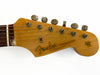Close-up of Fender Stratocaster guitar headstock with vintage tuning pegs and original contour body decal