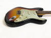 Vintage sunburst electric guitar with three single-coil pickups and white control knobs on white background