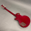 Red electric guitar backside with glossy finish and brown control cavity covers on gray background
