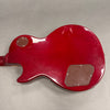 Back of red electric guitar body showing control cavity covers and glossy finish on gray background