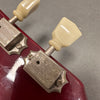Close-up of vintage Zount Zonmark guitar tuners with cream plastic tuning pegs on red guitar headstock