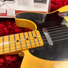 Close-up of vintage electric guitar neck and black pickguard with single-coil pickup on red plush background