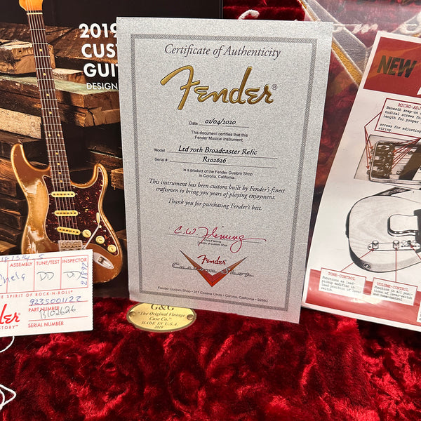 Fender Certificate of Authenticity for LTD 70th Broadcaster Relic guitar with serial number R102626, displayed on red velvet lining, alongside assembly and inspection tags and guitar information materials