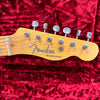 Close-up of Fender Broadcaster electric guitar headstock with six tuning pegs on red velvet background