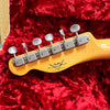 Close-up of Fender Custom Shop Limited Edition guitar headstock with vintage tuning machines on red plush case lining